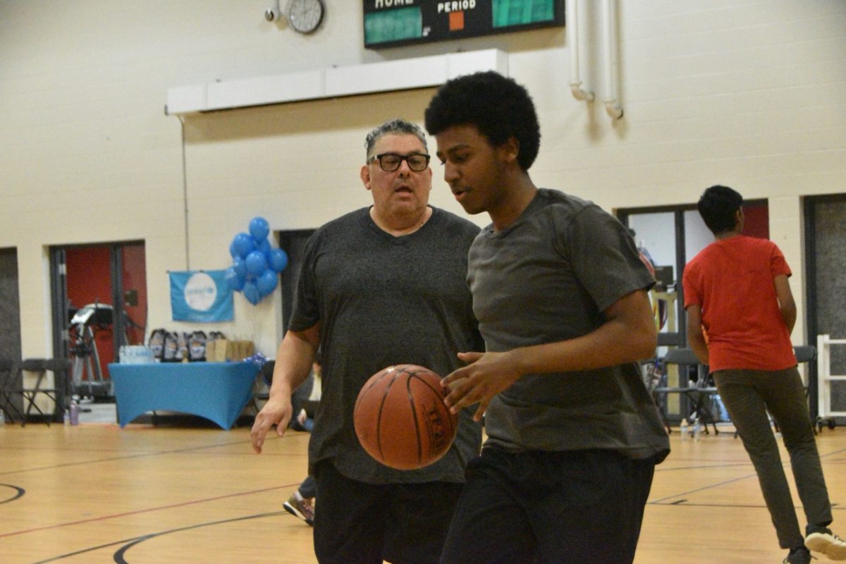 Adil Mekonnen dribbling the ball with Mr. Granado in the background.