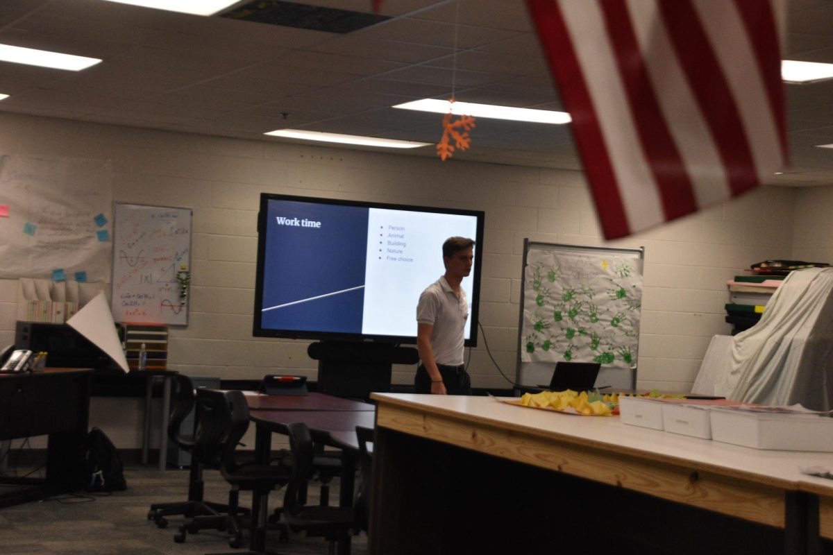 Lukas Stumm stands in front of his SPARK lesson plan for an Intro to AI Course. 