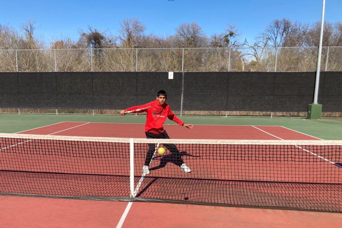 Suraj practicing tennis in Coppell High School tennis court.